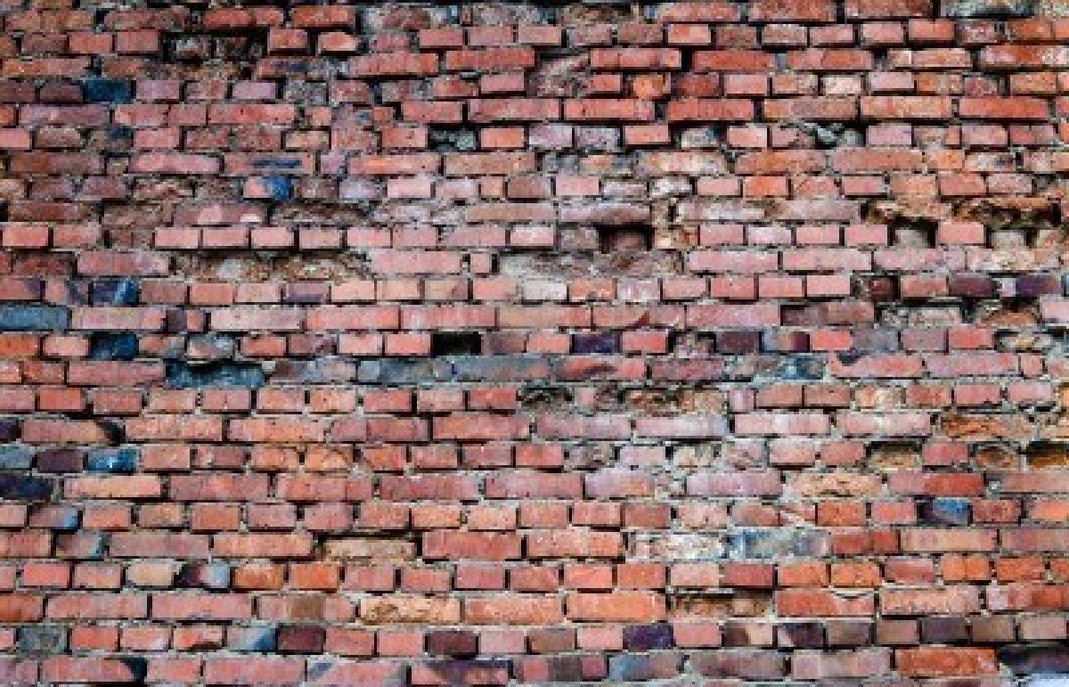 Met de rug tegen de muur.